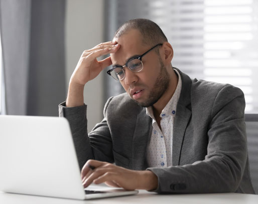 Frustrated man looking at a laptop