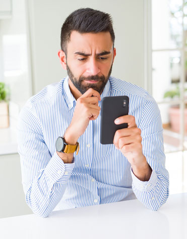 Confused man staring at his phone